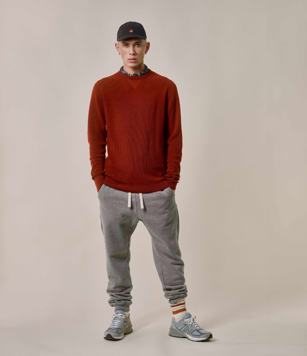 Man wearing red crewneck pullover and grey sweatpants