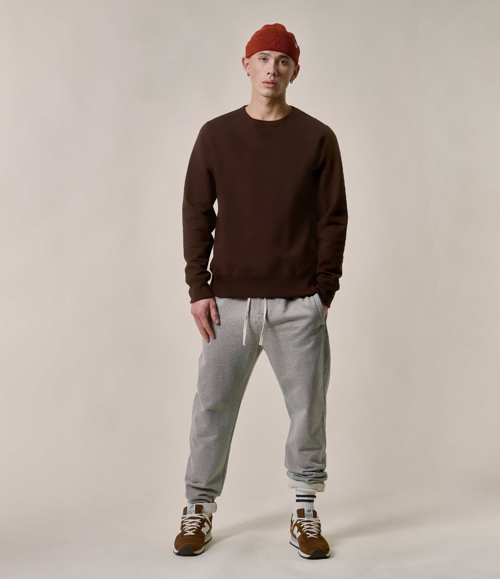 Man wearing brown crewneck sweatshirt and grey sweatpants