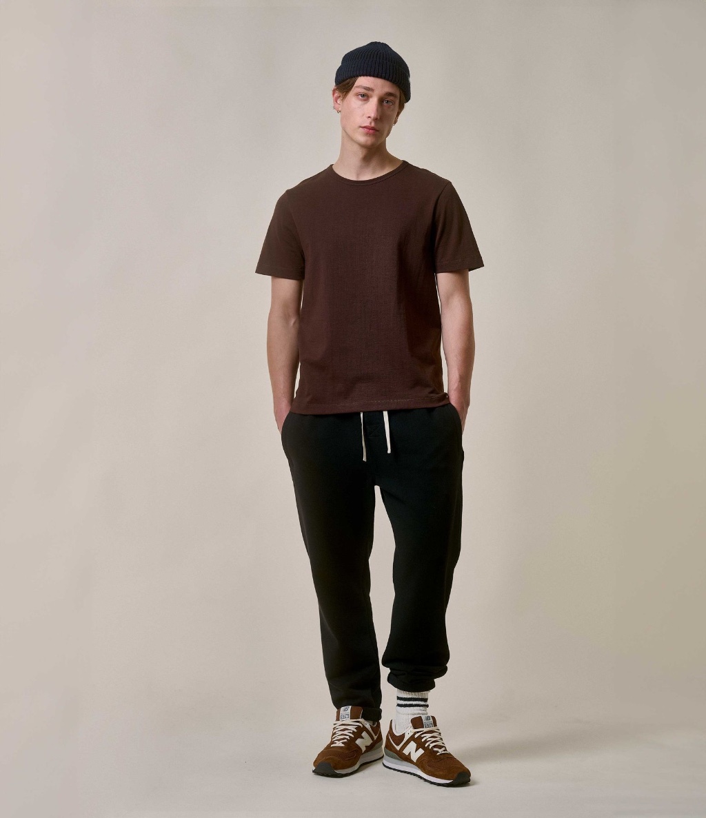 Man wearing brown crewneck T-shirt and heavy sweatpants