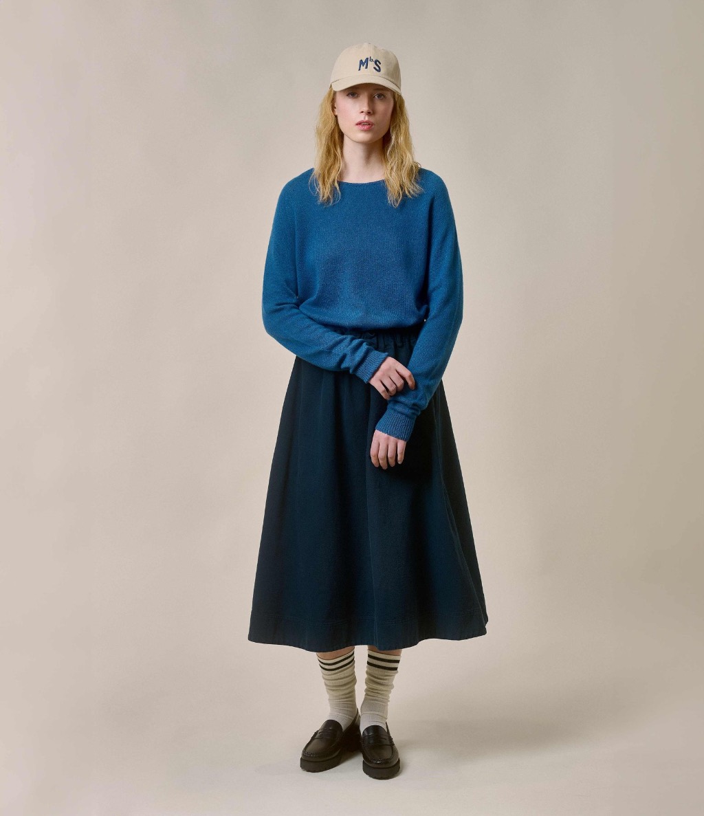 Woman wearing blue twill skirt and crewneck pullover