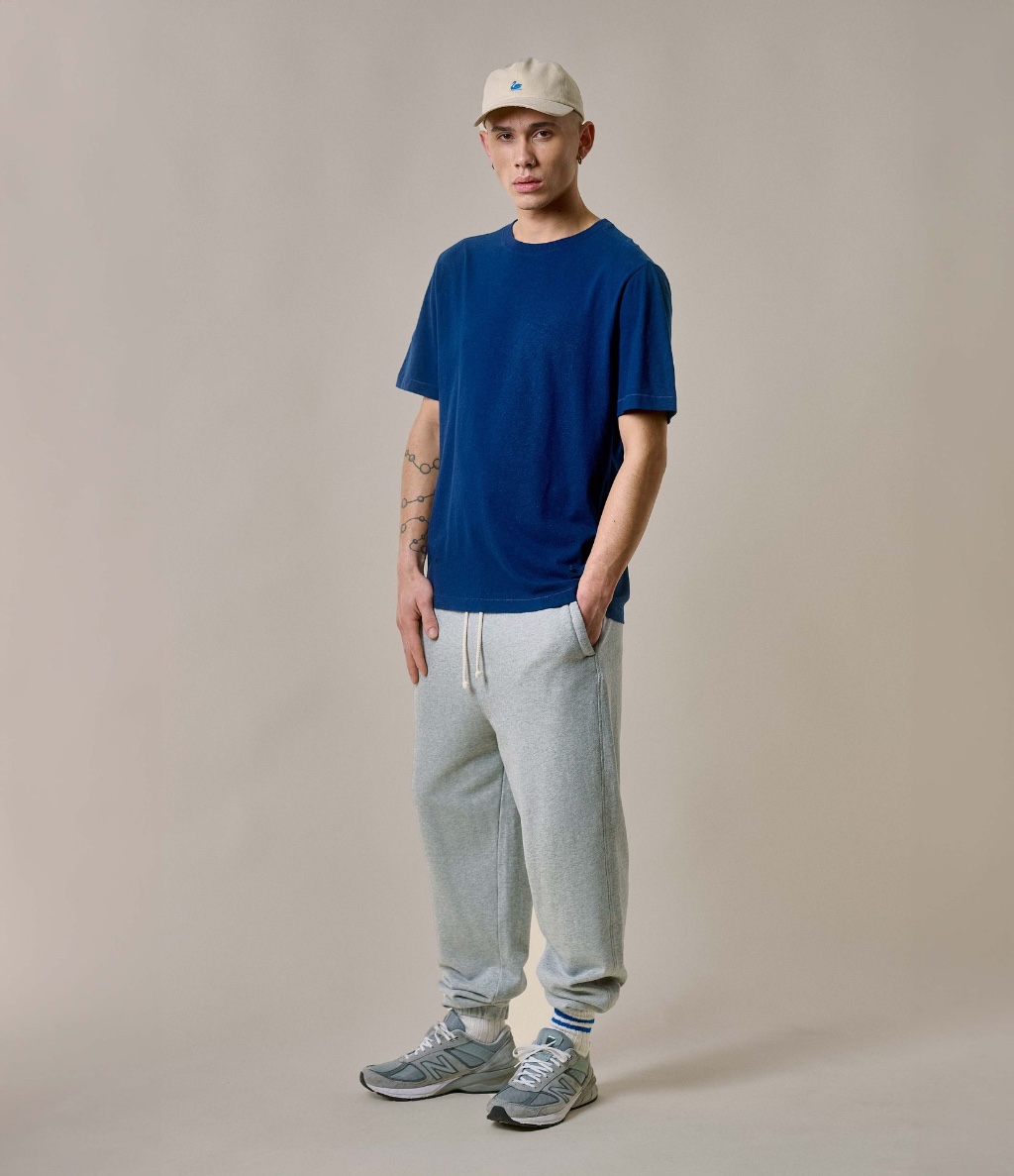 Man wearing blue crewneck T-shirt and grey sweatpants