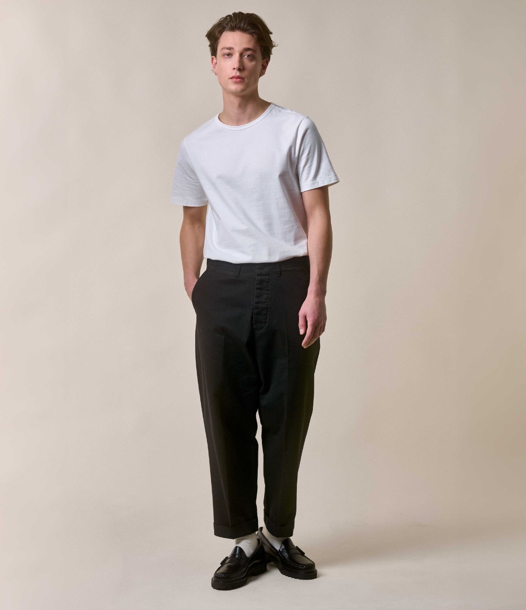 Man wearing white crewneck T-shirt and black twill chinos