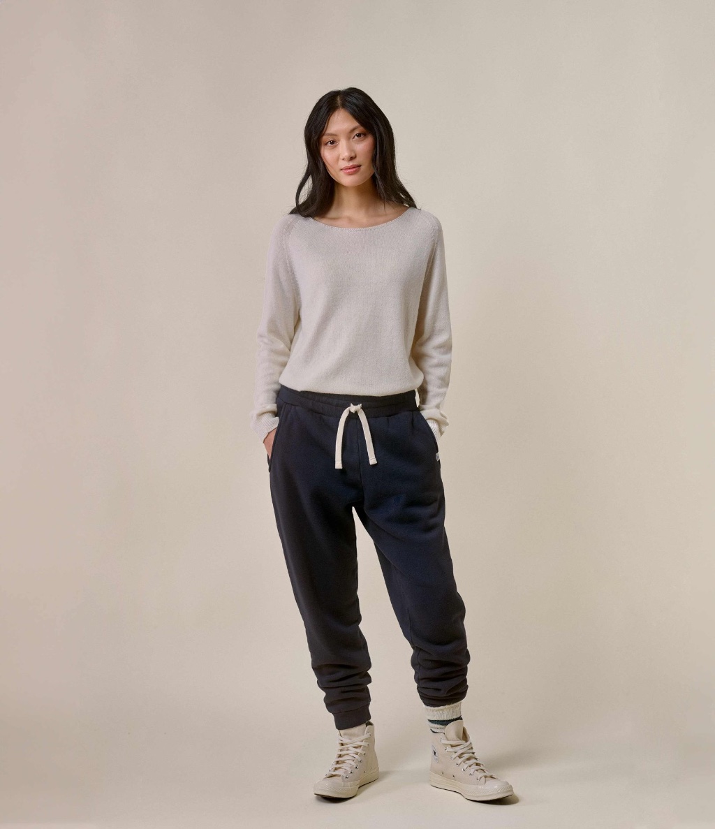 Woman wearing ecru crewneck pullover and grey sweatpants