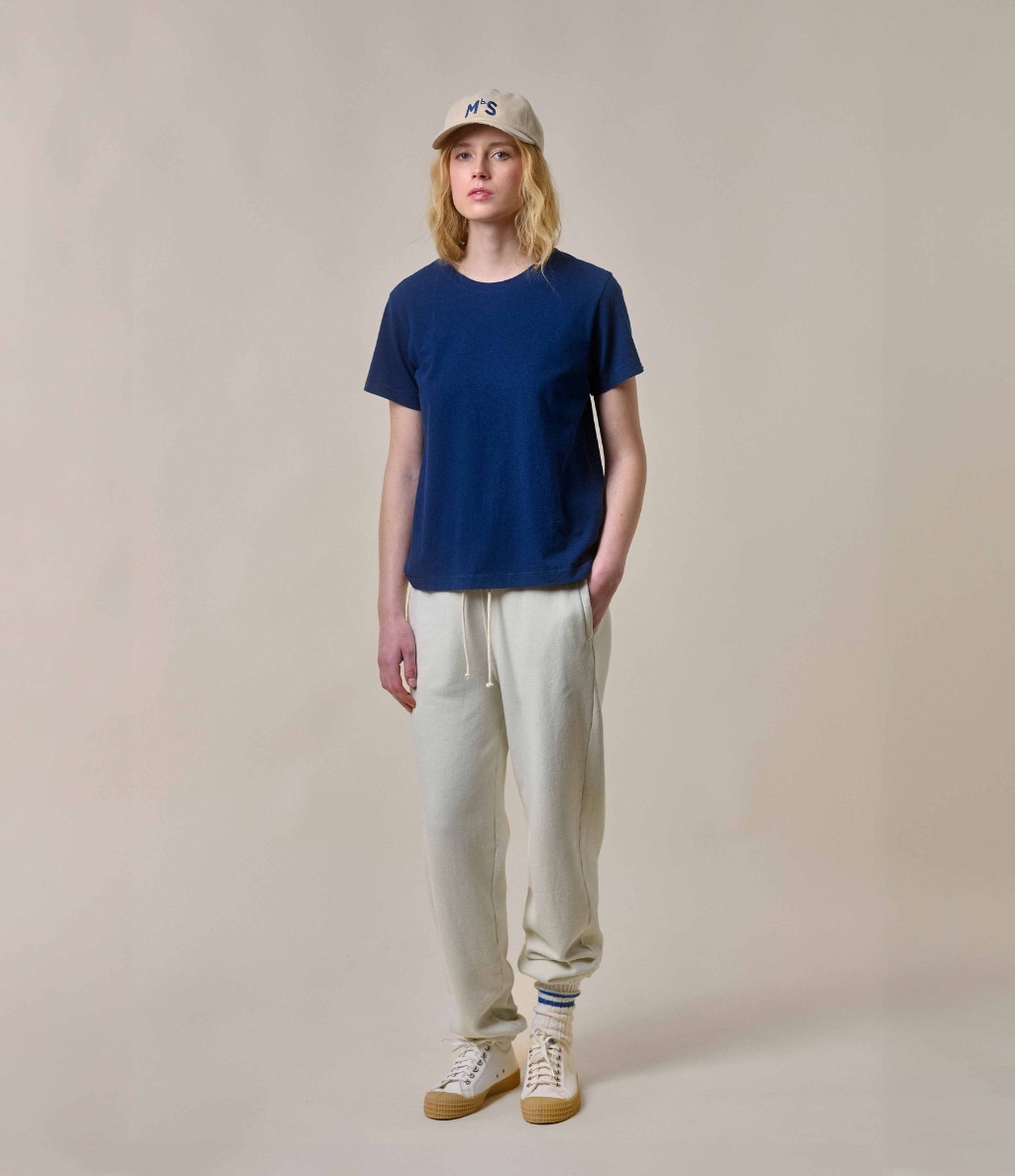 Woman wearing blue crewneck T-shirt and ecru sweatpants