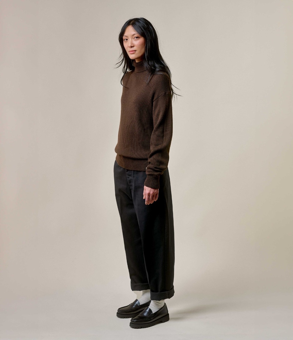 Woman wearing brown turtleneck pullover and black twill chinos