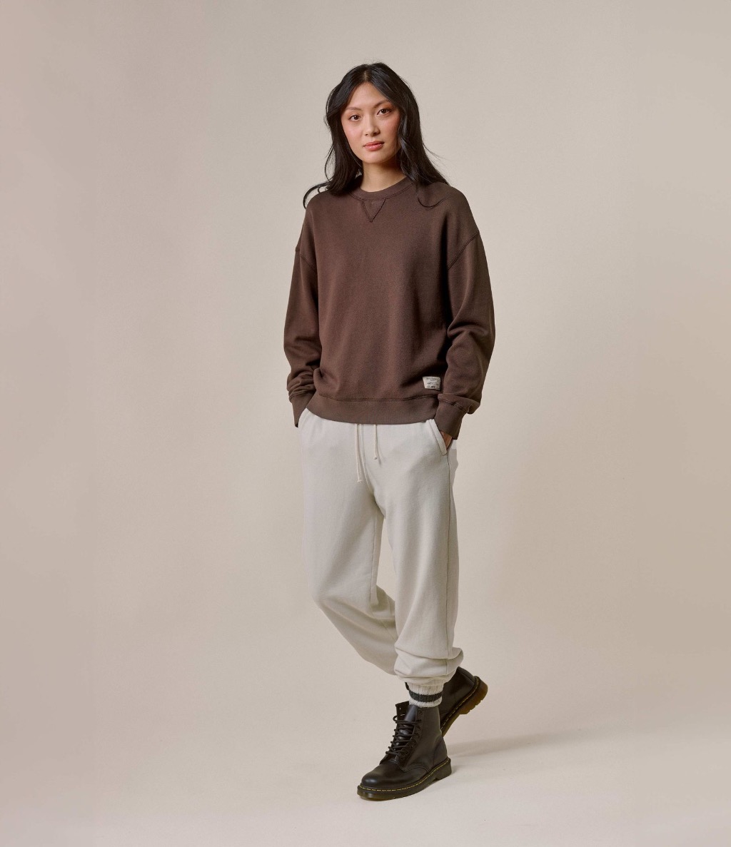 Woman wearing brown crewneck sweatshirt and ecru sweatpants