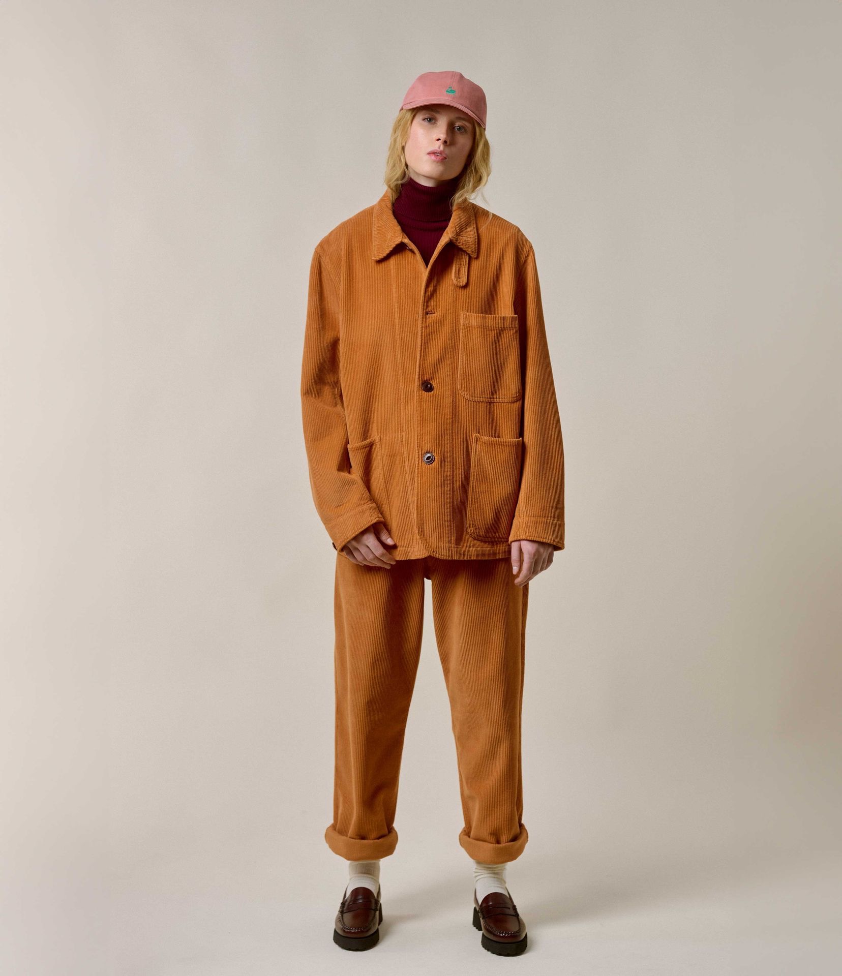 Woman wearing orange corduroy jacket and chinos with red turtleneck
