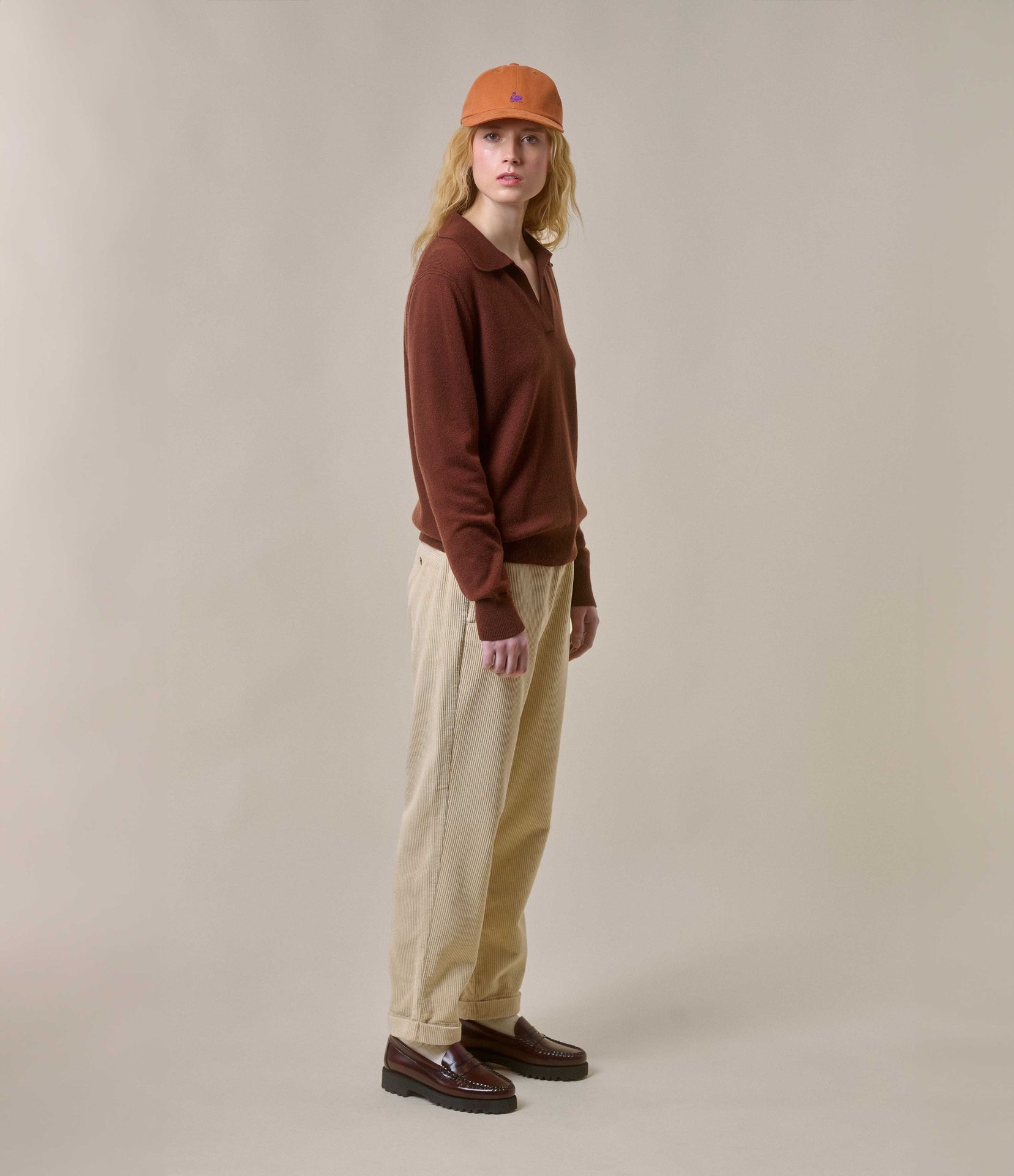 Woman wearing brown v-neck pullover and ecru corduroy chinos
