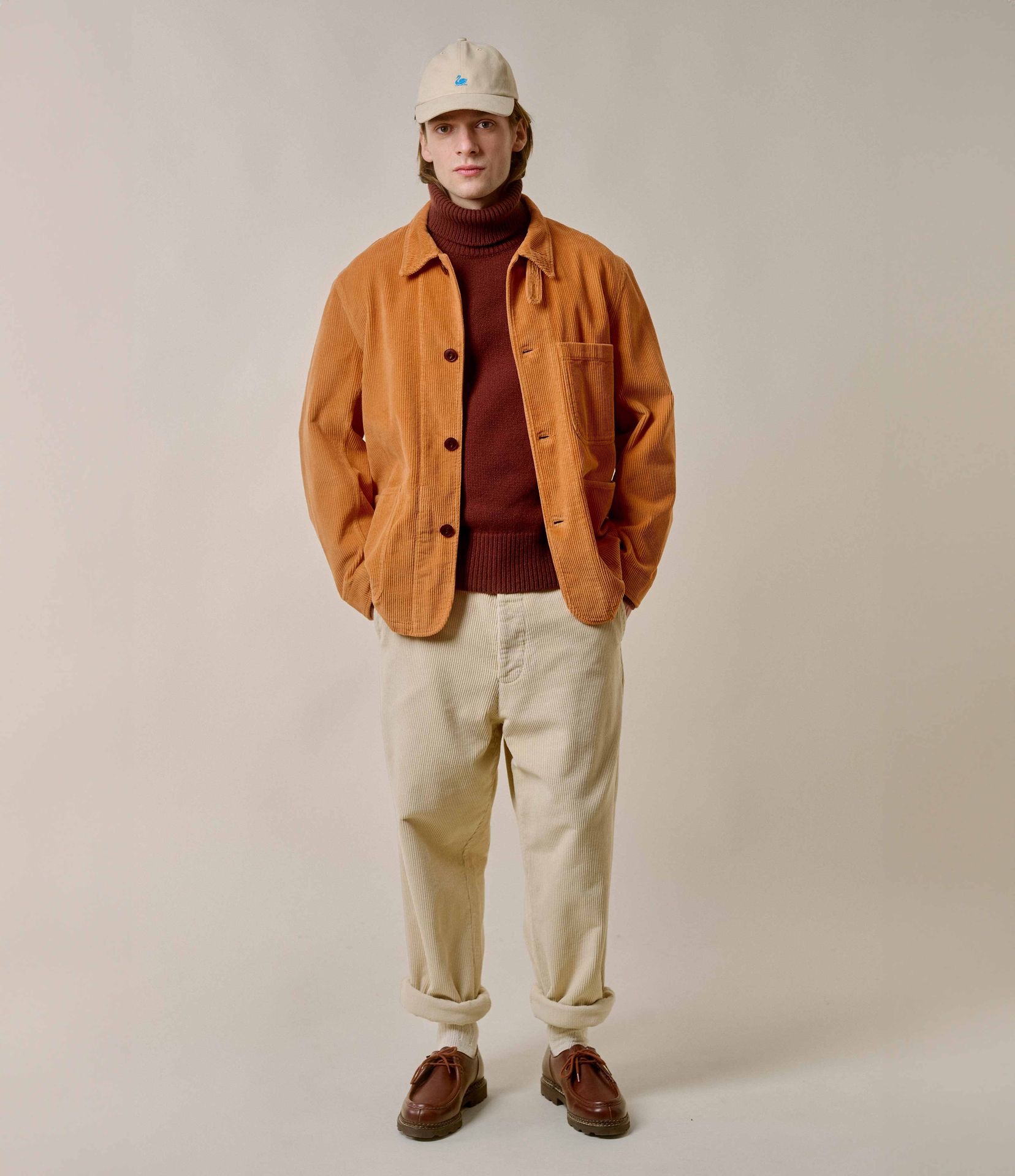 Man wearing orange corduroy jacket and ecru corduroy chinos