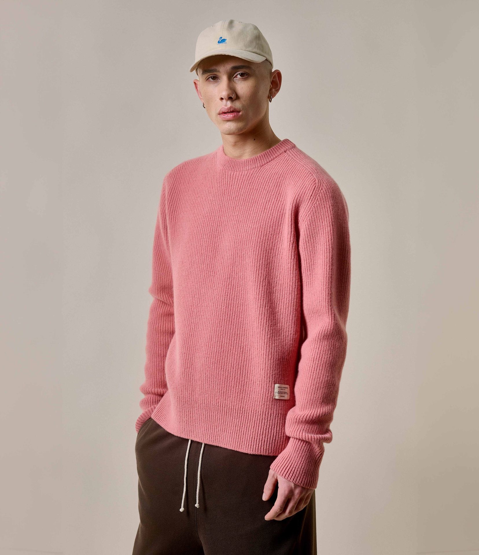 Man wearing pink crewneck pullover and brown sweatpants