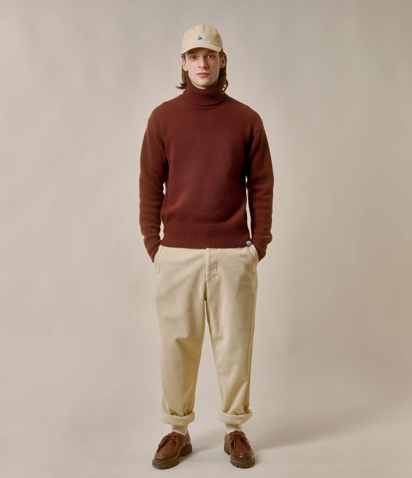 Man wearing brown turtleneck pullover and ecru corduroy chinos