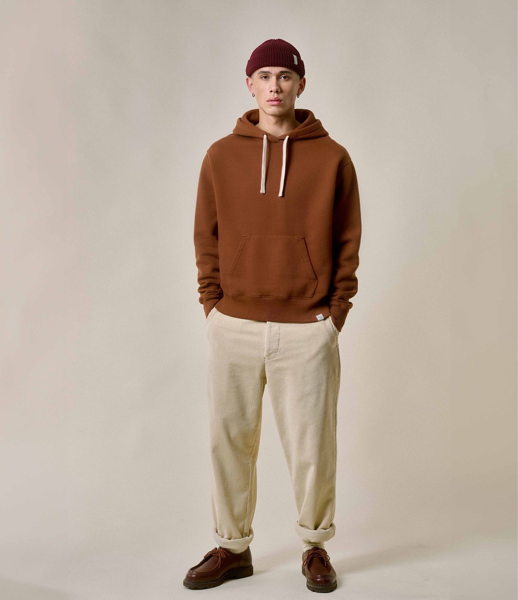 Man wearing brown hoodie and ecru corduroy chinos