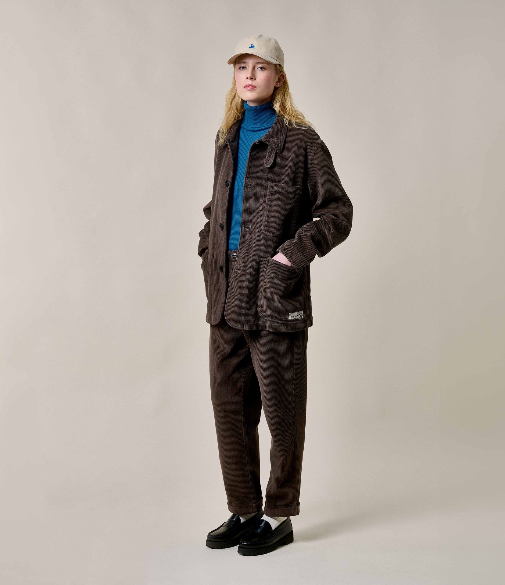 Woman wearing brown corduroy jacket and chinos with blue turtleneck