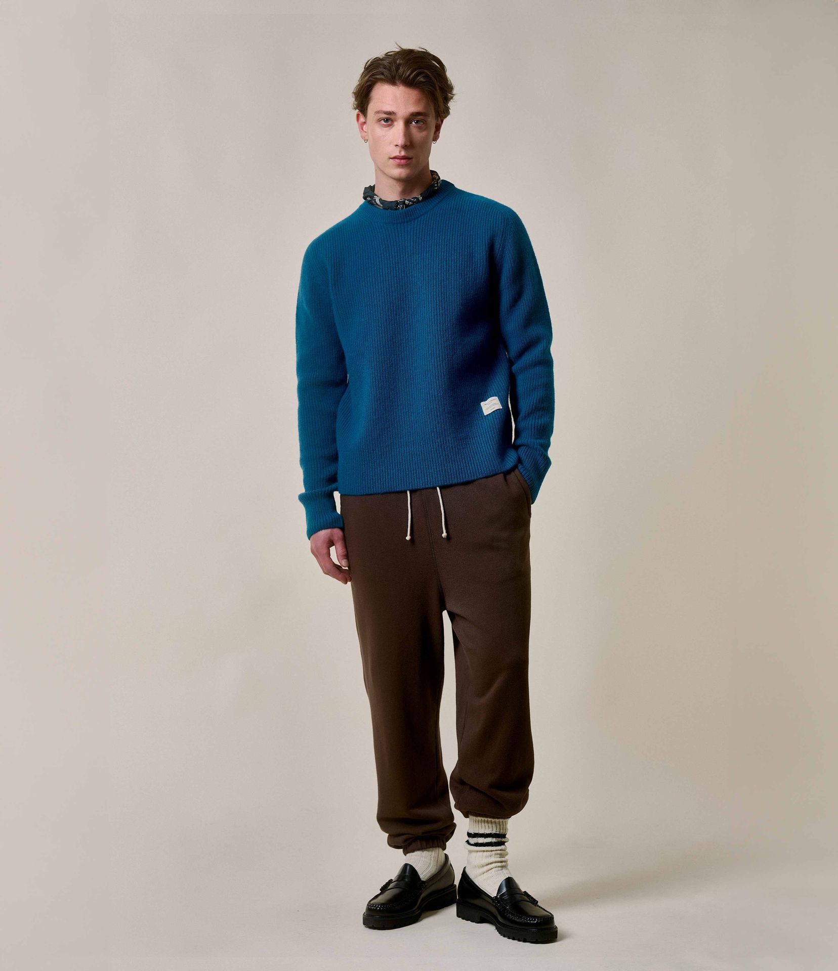 Man wearing blue crewneck pullover and brown sweatpants