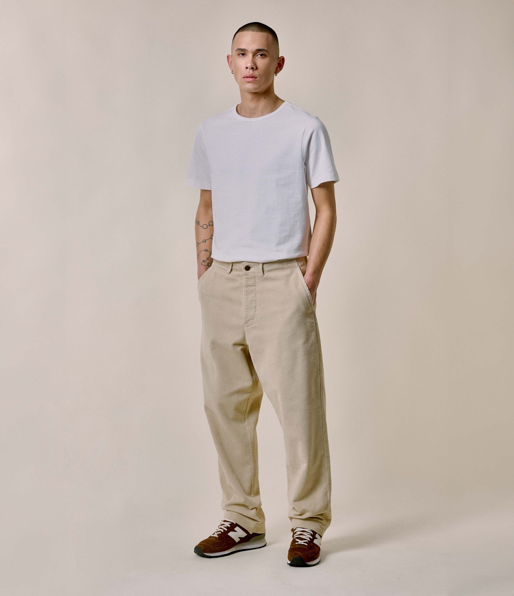 Man wearing white crewneck T-shirt and ecru corduroy chinos